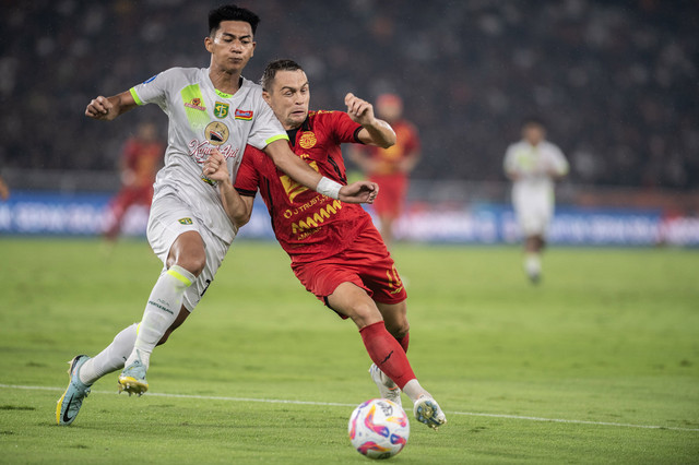 Pesepak bola Persija Jakarta Maciej Jacek Gajos (kanan) berebut bola dengan pesepak bola Persebaya Surabaya Malik Risaldi (kiri) pada pertandingan BRI Liga 1 di Stadion Utama Gelora Bung Karno, Senayan, Jakarta, Sabtu (12/4/2025). Foto: ANTARA FOTO/Bayu Pratama S