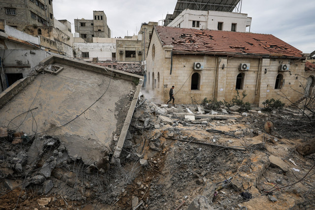 Warga Palestina memeriksa kerusakan setelah dua rudal Israel menghantam sebuah gedung di dalam Rumah Sakit Baptis Arab Al-Ahli di Kota Gaza, Minggu (13/4/2025). Foto: Dawoud Abu Alkas/REUTERS
