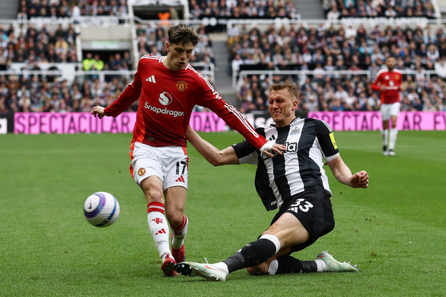 Pemain Newcastle United Dan Burn berebut bola dengan pemain Manchester United Alejandro Garnacho pada pertandingan Liga Inggris di St James' Park, Newcastle, Inggris, Minggu (13/4/2025). Foto: Lee Smith/REUTERS