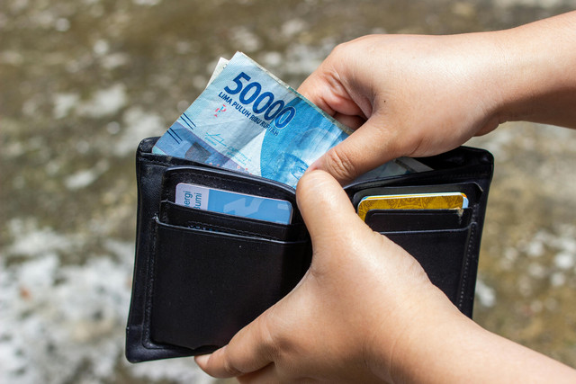 Foto oleh Ahsanjaya: https://www.pexels.com/id-id/foto/tangan-memegang-mata-uang-dompet-8764611/