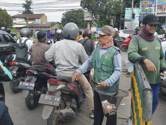 Aktivitas juru sumbangan pembangunan mesjid di lampu merah perempatan Teluk Pucung, Bekasi Utara, Selasa (15/4/2025). Foto: kumparan