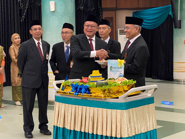 Direktur Utama Bank Kalbar, Rokidi saat memberikan potongan tumpeng kepada Komisaris Utama Bank, Eddy Suratman saat perayaan ulang tahun Bank Kalbar ke-61. Foto: Yulia Ramadhiyanti/Hi!Pontianak
