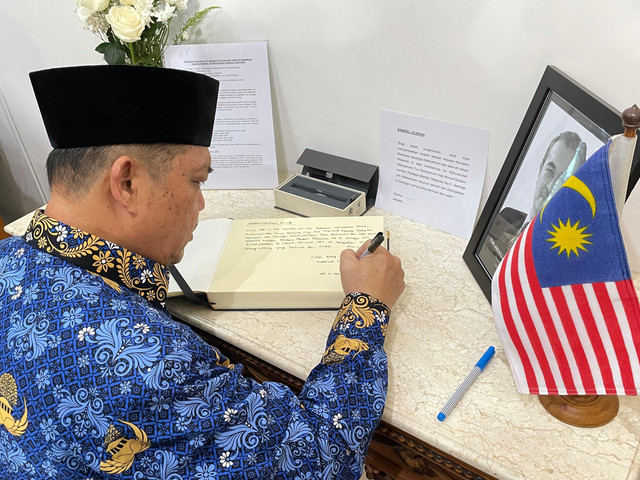 Gubernur Kalbar, Ria Norsan sesang menulis ucapannya diatas buku Takziah. Foto: Rabiansyah/Hi!Pontianak.