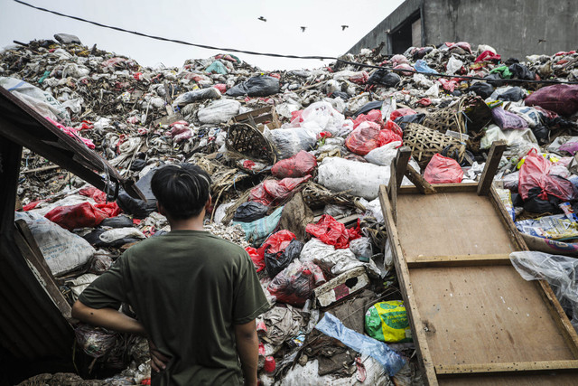 Seorang warga mengamati tumpukan sampah di Tempat Pembuangan sampah di Pasar Ciputat, Tangerang Selatan, Banten, Kamis (17/4/2025). Foto: Darryl Ramadhan/kumparan