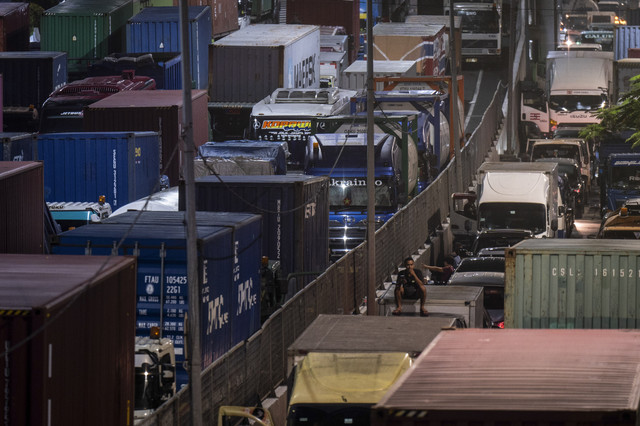 Warga duduk di atas mobil saat terjebak macet di Jalan Yos Sudarso menuju Pelabuhan Tanjung Priok, Jakarta, Kamis (17/4/2025). Foto: Bayu Pratama S/ANTARA FOTO