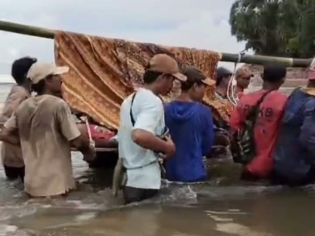 W arga Pekon Bandar Dalam, Kecamatan Bengkunat, Kabupaten Pesisir Barat bergotong royong menandu Kepala Desa (Peratin), yang sedang sakit menuju fasilitas kesehatan | Foto : Tangkap layar video