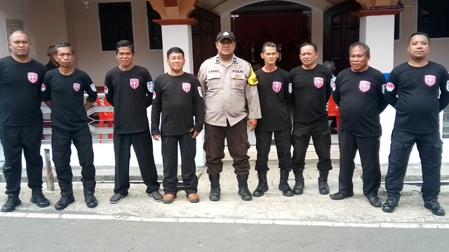 Personel Polres Bitung bersama dengan jemaat gereja, saat menjaga ibadah Jumat Agung di Kota Bitung, Sulawesi Utara.