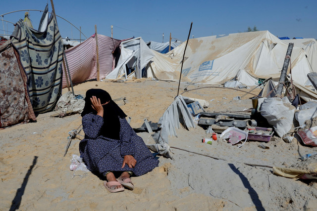Warga Palestina memeriksa kerusakan kamp tenda pengungsian usai serangan udara Israel di Khan Younis, Jalur Gaza selatan, Sabtu (19/4/2025). Foto: Hatem Khaled/REUTERS