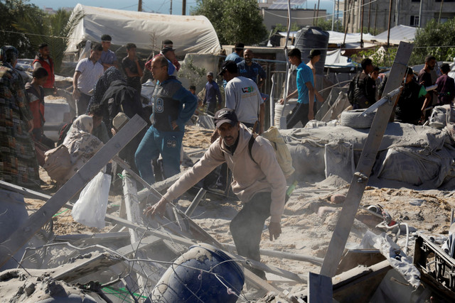 Warga Palestina memeriksa kerusakan kamp tenda pengungsian usai serangan udara Israel di Khan Younis, Jalur Gaza selatan, Sabtu (19/4/2025). Foto: Hatem Khaled/REUTERS