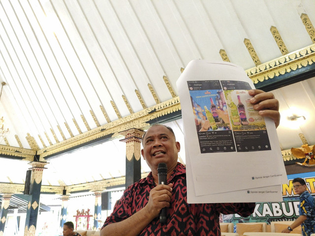 Bupati Sleman Harda Kiswaya menunjukkan foto produk minuman beralkohol yang menggunakan nama Kaliurang, Senin (21/4/2025). Foto: Arfiansyah Panji Purnandaru/kumparan