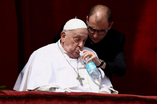 Paus Fransiskus muncul dari balkon utama Basilika Santo Petrus saat pesan Urbi et Orbi dan berkat kepada kota dan dunia dibacakan sebagai bagian dari perayaan Paskah di Vatikan, Minggu (20/4/2025). Foto: Guglielmo Mangiapane/REUTERS