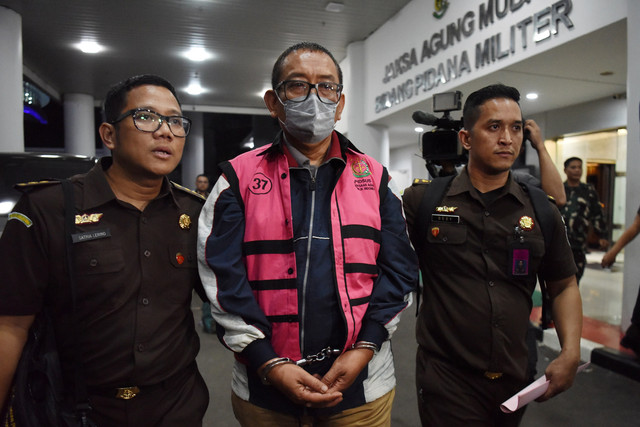 Direktur Pemberitaan JakTV Tian Bahtiar (tengah) dikawal petugas menuju mobil tahanan usai menjalani pemeriksaan di Gedung Kejaksaan Agung, Jakarta, Selasa (22/4/2025).  Foto: Indrianto Eko Suwarso/ANTARA FOTO