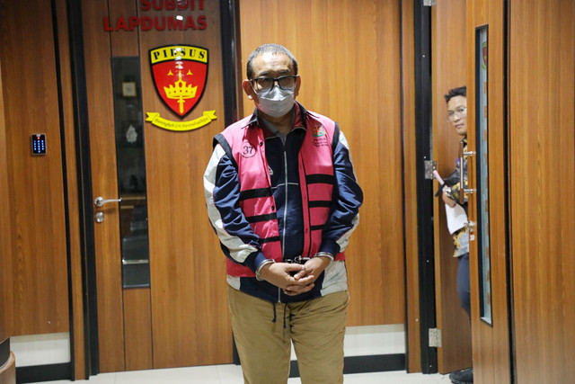 Direktur Pemberitaan JakTV Tian Bahtiar dikawal petugas menuju mobil tahanan usai menjalani pemeriksaan di Gedung Kejaksaan Agung, Jakarta, Selasa (22/4/2025).  Foto: Kejagung