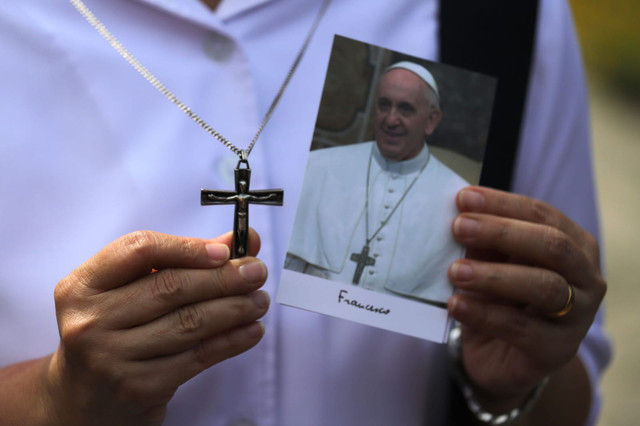 Warga menunjukkan foto Paus Fransiskus di Kedubes Vatikan untuk Indonesia, Jakarta, Selasa (22/4/2025). Foto: Jamal Ramadhan/kumparan