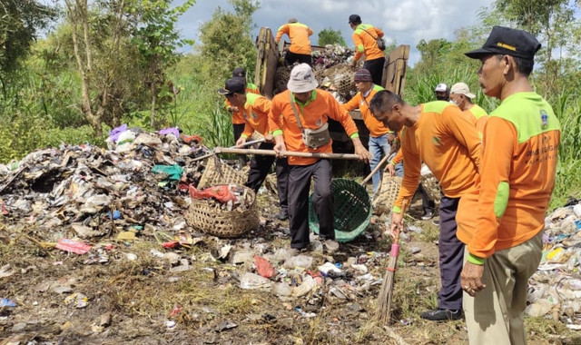 Petugas tengah membersihkan sampah yang dibuang di kawasan hutan negara di Playen, Gunungkidul. Foto: Dok. DLH Gunungkidul