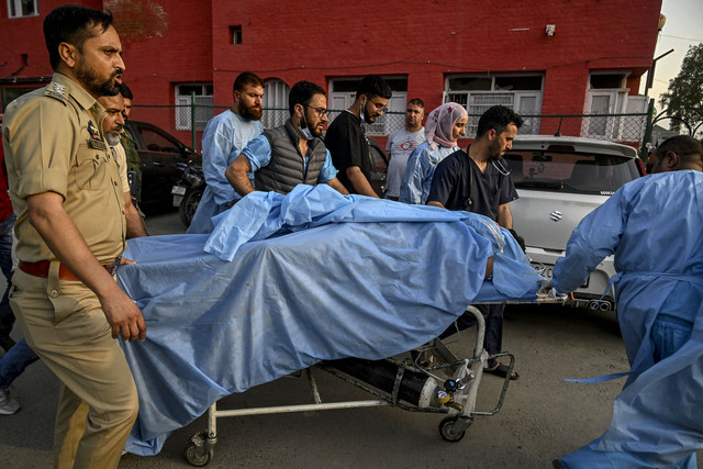 Petugas paramedis dan polisi membawa seorang turis yang terluka di sebuah rumah sakit di Anantnag, sebelah selatan Srinagar, India, Selasa (22/4/2025). Foto: TAUSEEF MUSTAFA/AFP