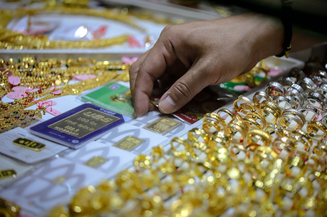 Pedagang mengambil emas batangan PT Antam di toko emas di kawasan Cikini, Jakarta, Rabu (23/4). Foto: Jamal Ramadhan/kumparan