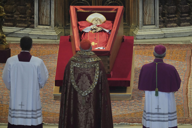 Kardinal Camerlengo Kevin Joseph Farrell, berdiri di depan jenazah Paus Fransiskus di dalam Basilika Santo Petrus di Vatikan, Rabu (23/4/2025). Foto: Andrew Medichini/Pool via REUTERS