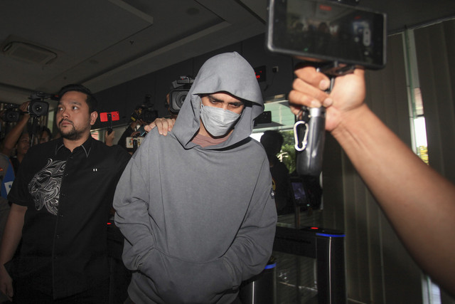 Aktor Fachri Albar (tengah) berjalan dengan kawalan polisi untuk menjalani pemeriksaan di Pusat Kedokteran dan Kesehatan (Pusdokkes) Polres Metro Jakarta Barat, Jakarta, Rabu (23/4/2025). Foto: Reno Esnir/ANTARA FOTO