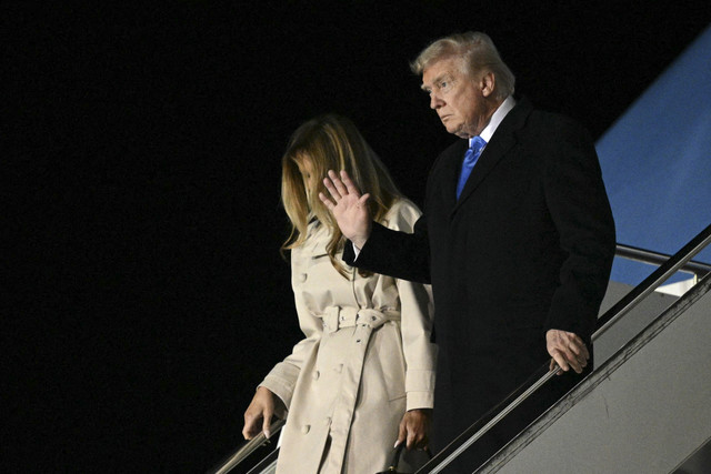 Presiden Amerika Serikat Donald Trump bersama Ibu Negara Melania Trump melambaikan tangan saat tiba untuk menghadiri pemakaman Paus Fransiskus di Bandara Internasional Leonardo da Vinci, Roma, Italia, Jumat (25/4/2025). Foto: Mandel Ngan/AFP