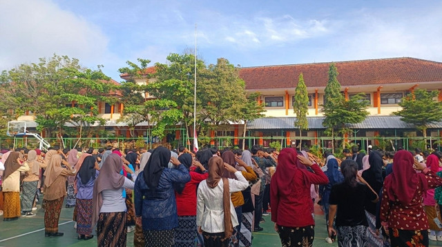 Ilustrasi Para siswa mengenakan kebaya dan batik saat mengikuti upacara Hari Kartini di halaman sekolah. Sumber: Shutter Stock