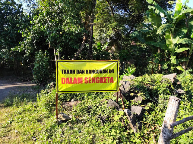 Spanduk bertuliskan "Tanah dan bangunan ini dalam sengketa" di RT 04 Dusun Ngentak, Kaluragan Bangunjiwo, Kapanewon Kasihan, Kabupaten Bantul, kepada Mbah Tupon korban mafia tanah. Foto: Arfiansyah Panji Purnandaru/kumparan