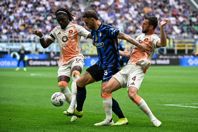 Pemain Inter Milan Marko Arnautovic berusaha melewati hadangan pemain AS Roma Manu Kone dan Bryan Cristante pada pertandingan Liga Italia di San Siro, Milan, Italia, Minggu (27/5/2025). Foto: Piero CRUCIATTI / AFP