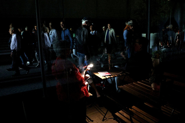 Warga menyalakan lampu ponselnya dalam kegelapan setelah pertandingan ditangguhkan karena pemadaman listrik di Park Manzanares, Madrid, Spanyol, Senin (28/4/2025). Foto: Violeta Santos Moura/REUTERS