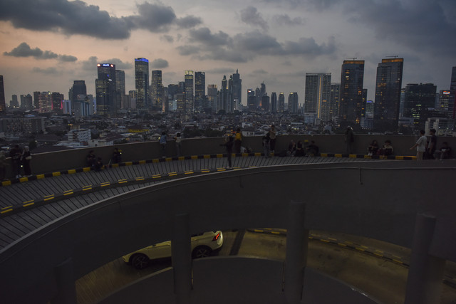 Warga berfoto dengan latar belakang gedung bertingkat di Jakarta, Rabu (30/4/2025). Foto: Indrianto Eko Suwarso/ANTARA FOTO