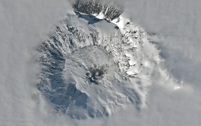 Citra satelit Gunung Erebus yang muncul melalui awan Antartika pada 25 November 2023. Foto: Landsat 9/NASA Earth Observatory