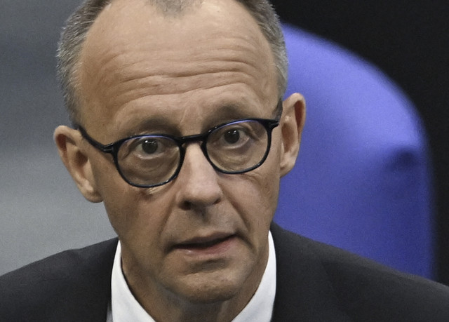 Calon Kanselir Jerman Friedrich Merz berjalan saat hasil pemungutan suara putaran pertama di Berlin, Jerman, Selasa (6/5/2025). Foto: RALF HIRSCHBERGER/AFP