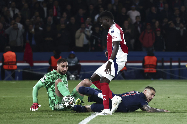 Kiper Paris Saint-Germain Gianluigi Donnarumma berebut bola dengan pemain Arsenal Bukayo Saka pada pertandingan leg kedua semifinal Liga Champions di Parc des Princes, Paris, Prancis, Rabu (5/8/2025). Foto: Thomas Samson/AFP
