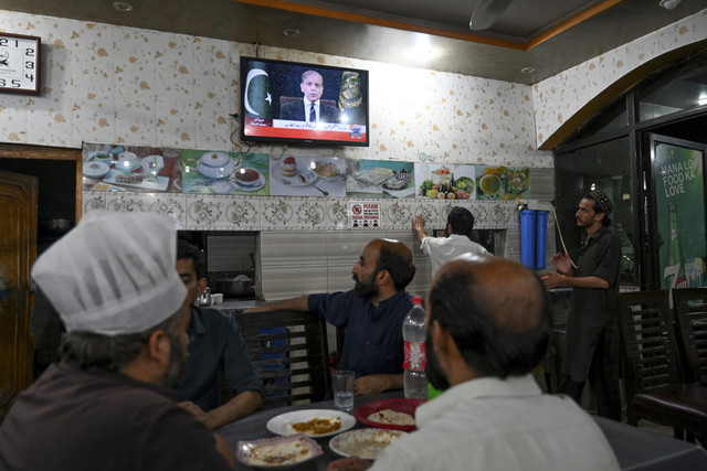 Sejumlah warga menyaksikan Perdana Menteri Pakistan Shehbaz Sharif berpidato dari televisi saat konflik antara India dan Pakistan di salah satu restoran di Islamabad, Pakistan, Rabu (7/5/2025). Foto: Aamir Qureshi/AFP