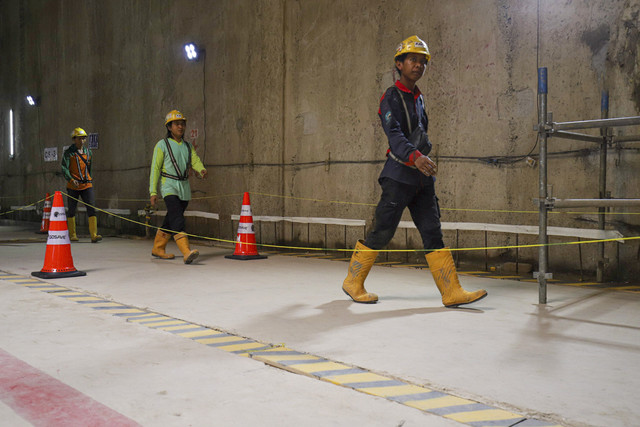 Pekerja melintas proyek MRT Fase 2A di Stasiun MRT Harmoni, Jakarta, Jumat (9/5/2025). Foto: Iqbal Firdaus/kumparan