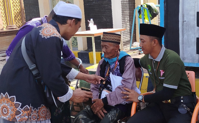 Petugas haji sedang menenangkan jemaah haji asal Jember yang mengalami demensia. Foto: Humas Kemenag Jatim 