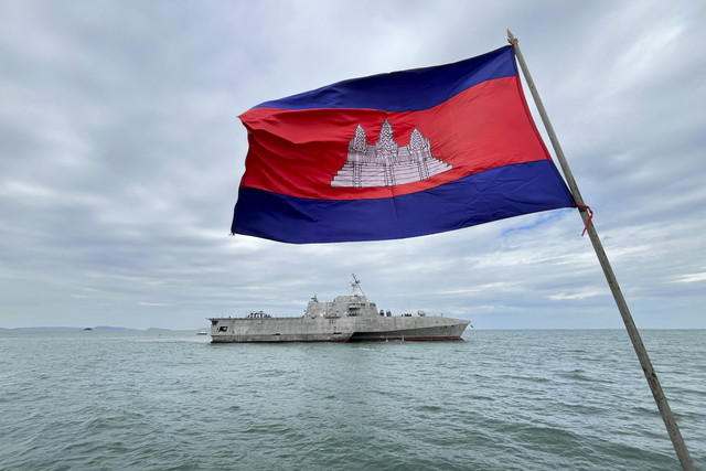 Personel Angkatan Laut Kamboja menyaksikan kapal tempur USS Savannah berlabuh di kota pelabuhan selatan Kamboja, Sihanoukville, pada 16 Desember 2024. Foto: Suy Se/AFP