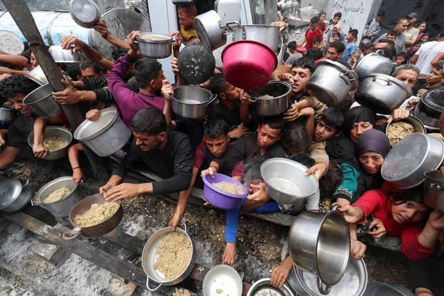 Warga Palestina menunggu untuk menerima makanan yang dimasak oleh dapur amal, di Jabalia, di Jalur Gaza utara, 14 Mei 2025. Foto: REUTERS/Mahmoud Issa