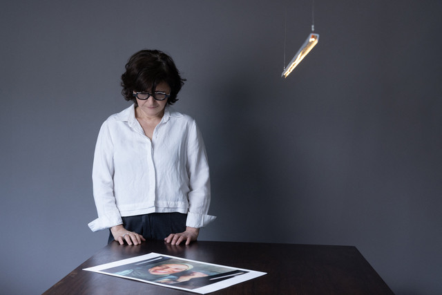 Pembuat film dan aktivis Iran Sepideh Farsi melihat potret fotografer Palestina Fatima Hassouna, selama sesi foto di rumahnya di Paris pada 5 Mei 2025. Foto: JOEL SAGET / AFP