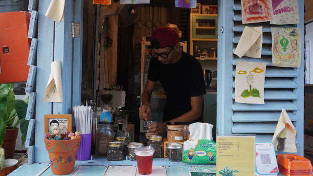 Pemilik dari Kurindu Rumah, Rachman, saat sedang menyiapkan pesanan pelanggan di warung estetiknya/Anyelir. 