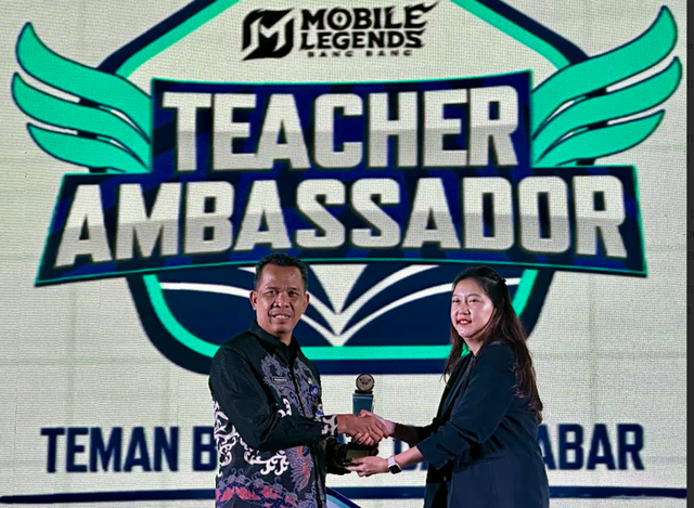 PLT Kepala Cabang Dinas Pendidikan Provinsi Jawa Timur wilayah Surabaya, Gresik dan Sidoarjo, Kiswanto (kiri) saat menerima cinderamata dari Erina Tan Kepala Bidang Pengembangan Ekosistim Gim Moonton Indonesia saat MLBB Teacher Ambassador di DoubleTree Hotel Surabaya, kemarin, Kamis (15/5/2025).FOTO dan Teks: DIPTA WAHYU/BASRA