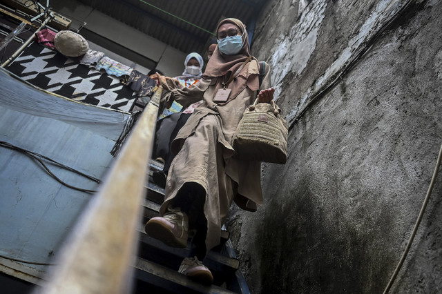 Usai Memeriksa Pasien: Perawat paliatif Tyas menuruni tangga di permukiman padat penduduk usai memeriksa pasiennya di Jakarta. Foto: Rivan Awal Lingga/ANTARA FOTO