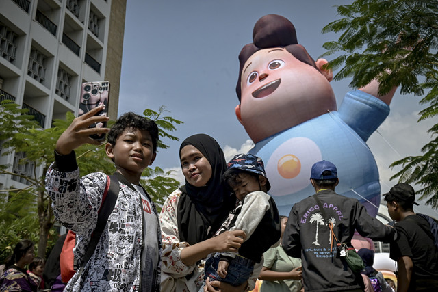 Warga berswafoto dengan balon raksasa Don 'JUMBO' saat berwisata di Kota Tua, Jakarta, Minggu (18/5/2025). Foto: Jamal Ramadhan/kumparan