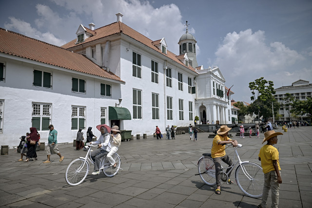 Sejumlah warga bermain sepeda saat berwisata di Kota Tua, Jakarta, Minggu (18/5/2025). Foto: Jamal Ramadhan/kumparan