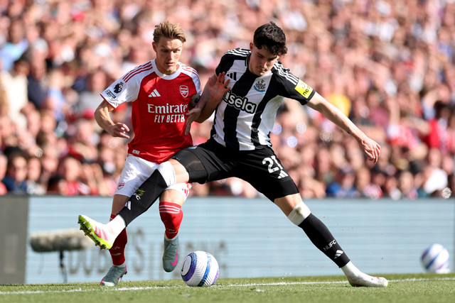 Pemain Arsenal Martin Odegaard berebut bola dengan pemain Newcastle United Tino Livramento pada pertandingan Liga Inggris di Stadion Emirates, London, Inggris, Minggu (18/5/2025). Foto: John Sibley/REUTERS