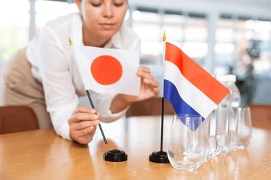 Bendera Jepang dan Belanda. Sumber: https://www.shutterstock.com/image-photo/young-woman-business-clothes-puts-flags-2345544719