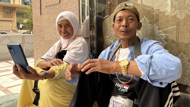 Mardi dan Tri, pasangan jemaah haji saat di Makkah sedang menelepon keluarga. Foto: Moh Fajri/kumparan