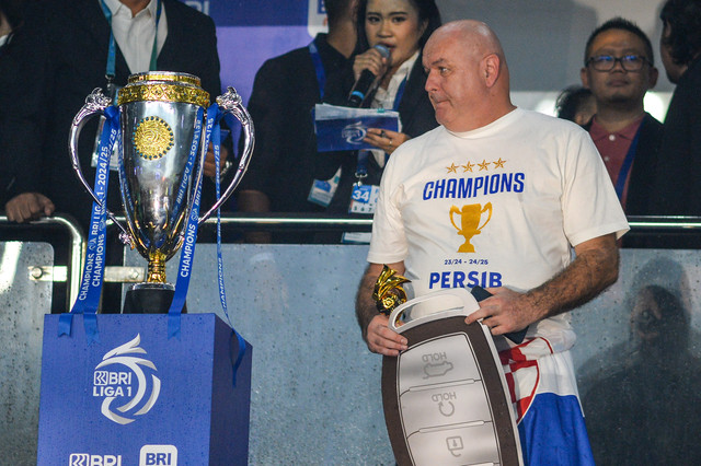 Pelatih Persib Bandung Bojan Hodak (kanan) melihat piala liga 1 saat acara penghargaan bagi pemain dan ofisial tim BRI Liga 1 di Stadion Gelora Bandung Lautan Api (GBLA), Bandung, Jawa Barat, Sabtu (24/5/2025). Foto: ANTARA FOTO/Raisan Al Farisi