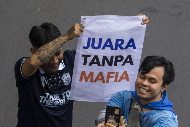 Warga membawa poster untuk menyaksikan pawai keberhasilan tim Persib Bandung menjuarai Liga 1 di Jalan Wastukencana, Kota Bandung, Minggu (25/5/2025). Foto: Novrian Arbi/ANTARA FOTO