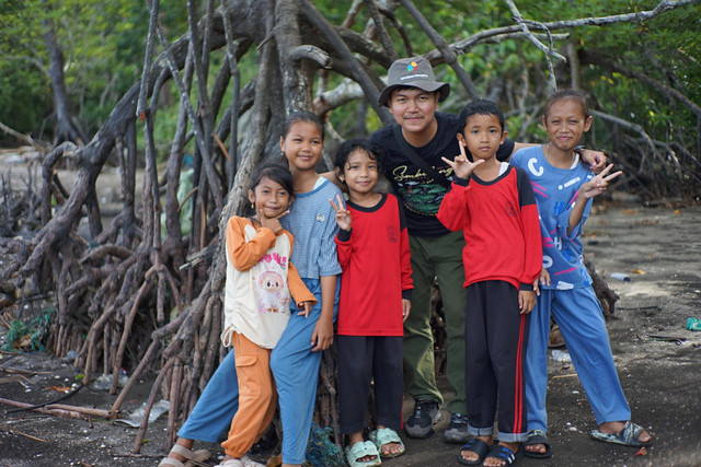 Koordinator Komunitas Mangjaki, Dinar Try Akbar, saat mengunjungi anak-anak yang tinggal di pesisir/ist. 