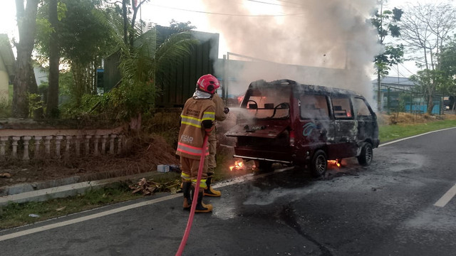 Petugas, saat lakukan pemadaman mobil Suzuki Carry yang terbakar di Jalan Raya Bojonegoro-Nganjuk, turut Desa Temayang, Kecamatan Temayang, Kabupaten Bojonegoro. Senin (26/05/2025) (Foto: Dok Istimewa)